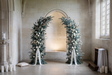 Fond photo Veillée de pierre de la collection Arches Noël 2026 - calcaire clair, sapin, eucalyptus - portrait couple Noël intemporel